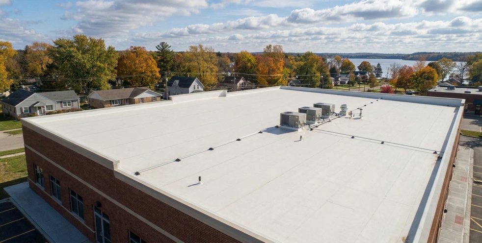 New flat roof on a commercial building with HVAC units near a Michigan lake